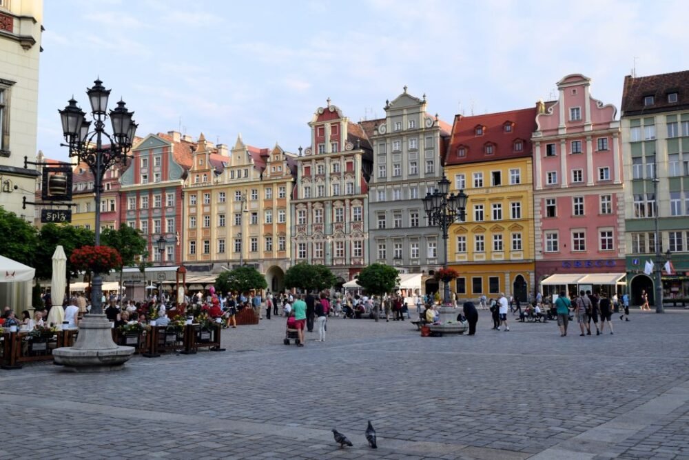 Things To See, Eat & Do In Wroclaw, Poland During Your Stay! Wroclaw Market Square with colorful buildings and pedestrians
