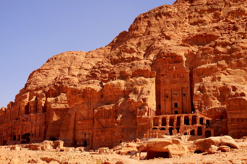 Tombs and temples carved into the rock in Petra, Jordan from a distant vantage point on a bright and sunny day