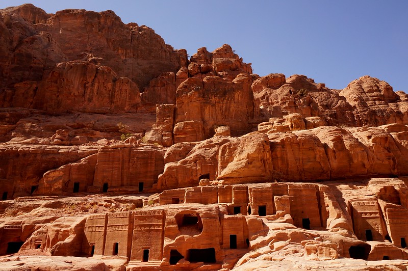 Tombs carved into the red rock in Petra, Jordan from a wide angle vantage point are so fascinating they almost look surreal to the eye