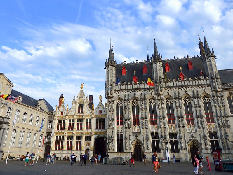 Town Hall in Bruges done in the Gothic style with pedestrians visiting the town square Town Hall in Bruges done in the Gothic style with pedestrians visiting the town square