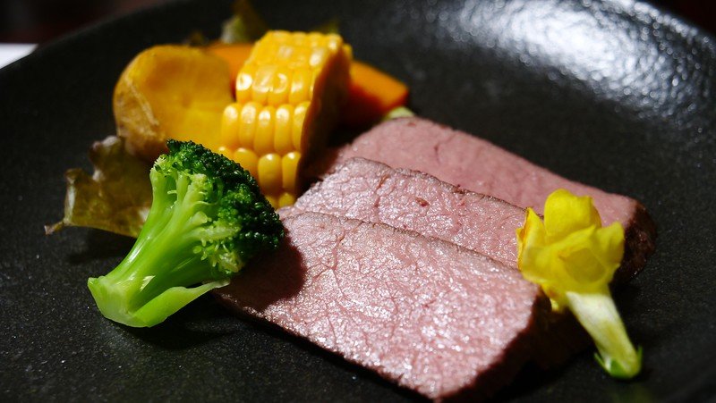 Traditional Hida beef is a dish to try in Takayama, Japan as presented with corn and broccoli along with floral touches