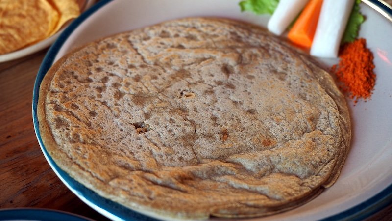 Traditional Nepali buckwheat flatbread served with fresh vegetables and spices in Kathmandu, Nepal, a classic local food experience