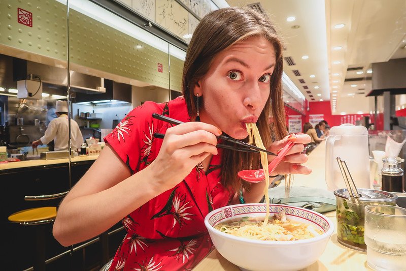 Trying ramen in Osaka, which I ordered from a vending machine is a slurping That Backpacker Audrey Bergner enjoying every tasty bite in Japan