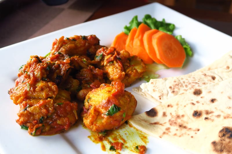 Trying the local Nepalese food in Pokhara with lots of spice and tasty bread in Nepal