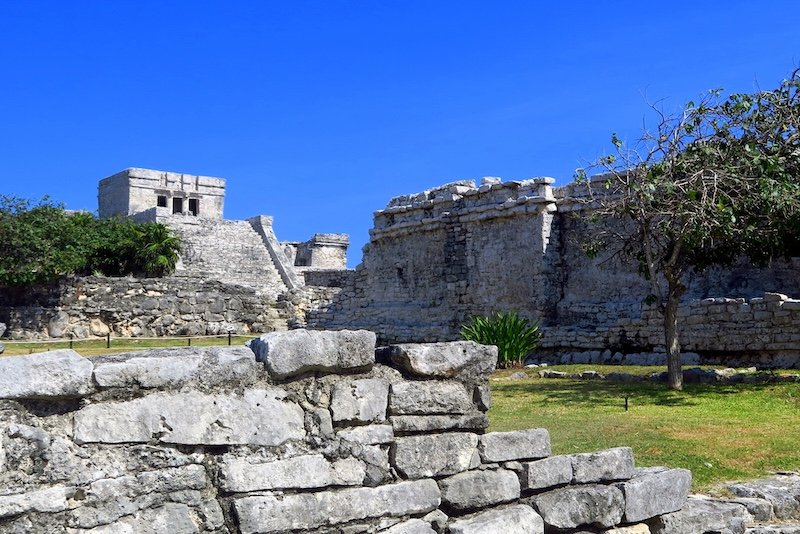 Ancient stone structures of the Tulum ruins basking under a vivid blue sky, showcasing the enduring architecture of the Maya civilization on Mexico’s Caribbean coast Ancient stone structures of the Tulum ruins basking under a vivid blue sky, showcasing the enduring architecture of the Maya civilization on Mexico’s Caribbean coast