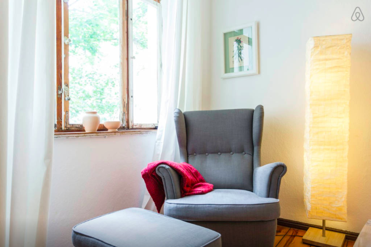 Using AirBnB in Berlin, Germany with a comfortable sofa and views outside of our window overlooking a park 