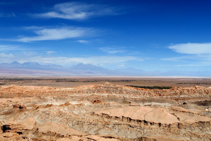 Panoramic view of Valle de la Luna in Chile’s Atacama Desert with dramatic rock formations and Andes Mountains in the distance