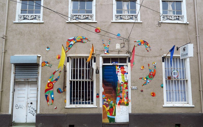 Whimsical street art and brightly painted doors in Valparaíso, Chile, showcasing the city’s creative bohemian charm and vibrant urban culture