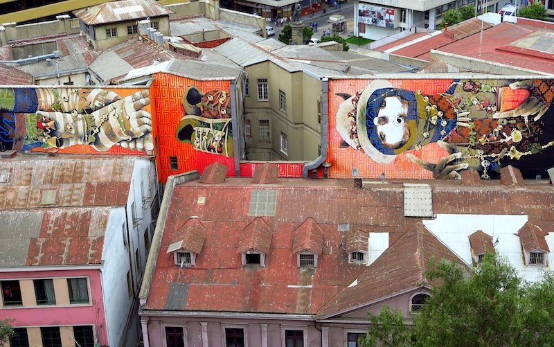 Colorful rooftop murals on historic buildings in Valparaíso, Chile, showcasing the city’s famous street art and bohemian culture