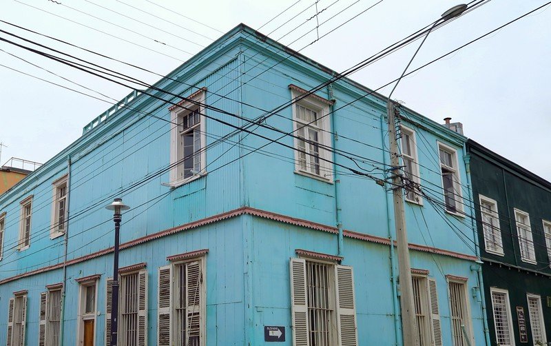 Historic pastel blue seaport-style architecture with wooden shutters and corrugated metal walls in Valparaíso, Chile’s UNESCO-listed port city