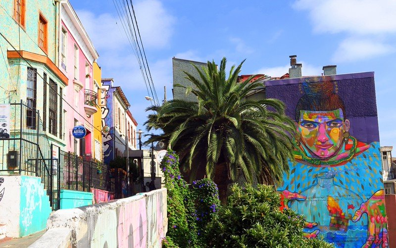 Vibrant street art mural and colorful colonial houses in the bohemian hills of Valparaíso, Chile’s UNESCO World Heritage port city
