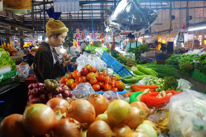 Vendors selling fresh produce at the local wet market in Chiang Mai, Thailand 