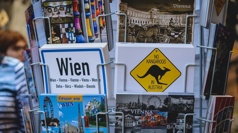 Display rack of humorous Vienna postcards, including one reading “No Kangaroos in Austria” alongside scenic images of city landmarks and attractions Display rack of humorous Vienna postcards, including one reading “No Kangaroos in Austria” alongside scenic images of city landmarks and attractions