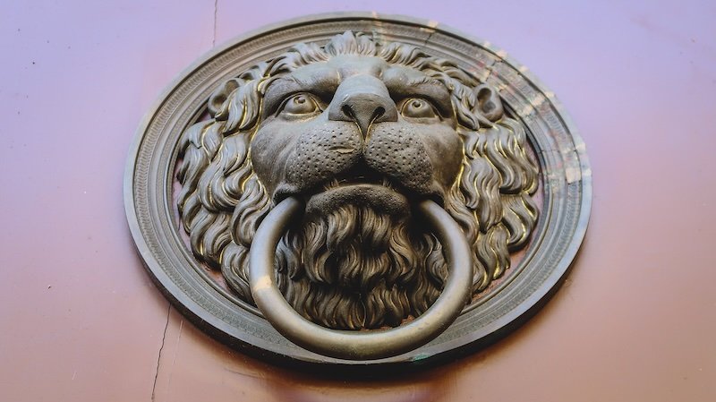 Close-up of an ornate lion-shaped brass door knocker on a historic building in Vienna, Austria, showcasing the city’s elegant architectural details Close-up of an ornate lion-shaped brass door knocker on a historic building in Vienna, Austria, showcasing the city’s elegant architectural details