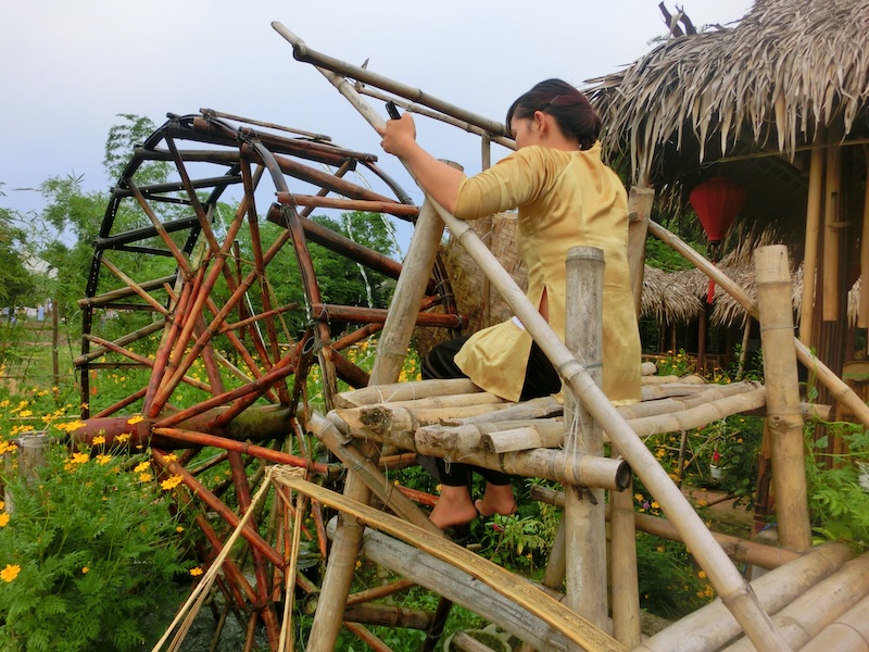 Vietnamese lady demonstrating how to use the water wheel at Tra Que Herb village in Vietnam 