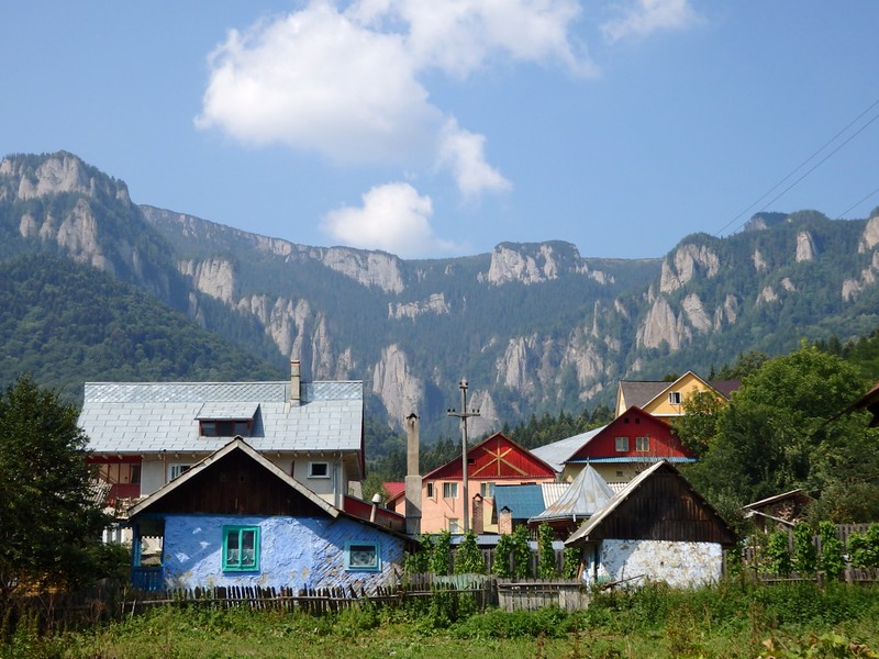 Views after completing our hike in Ceahlău National Park, Romania with houses in the foreground and mountains in the backdrop