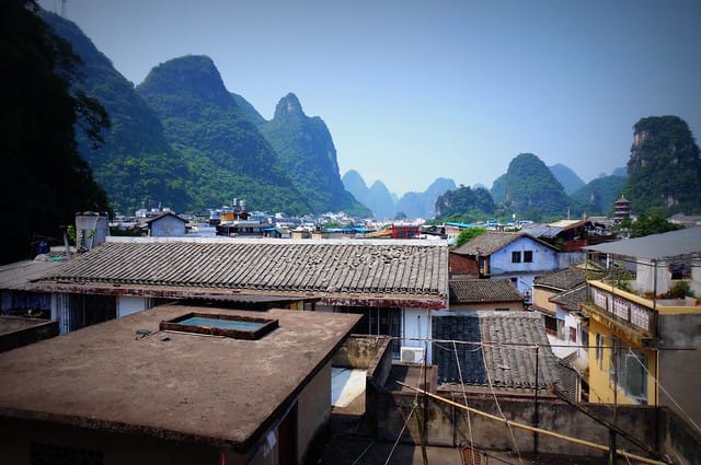 Views of the limestone mountains in Yangshuo in China with traditional Chinese architecture and roofs 