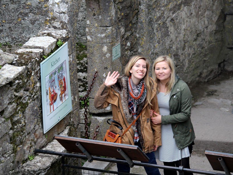 Visiting Blarney Castle with a waving That Backpacker Audrey Bergner and her best friends side by side enjoying it all together on a road trip