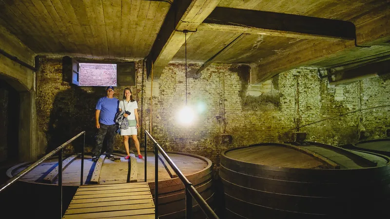 Visiting the champañera at Bodegas Lopez with Daniel Bergner and Audrey Bergner posing by giant barrels of wine in Mendoza in Argentina