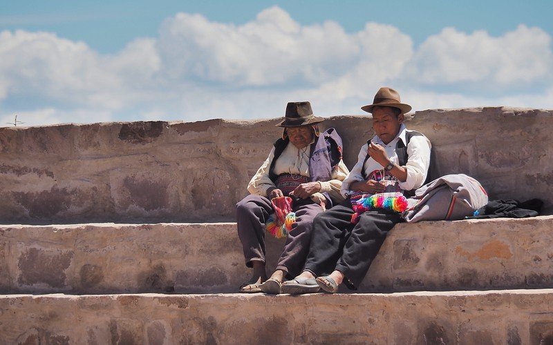 Visiting the islands of Lake Titicaca where we encountered locals hanging out on steps wearing traditional Peruvian clothes and bowler hats 