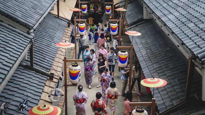 Visiting the Osaka Museum of Housing and Living with visitors dressed in traditional kimonos and Japanese attire in Japan 
