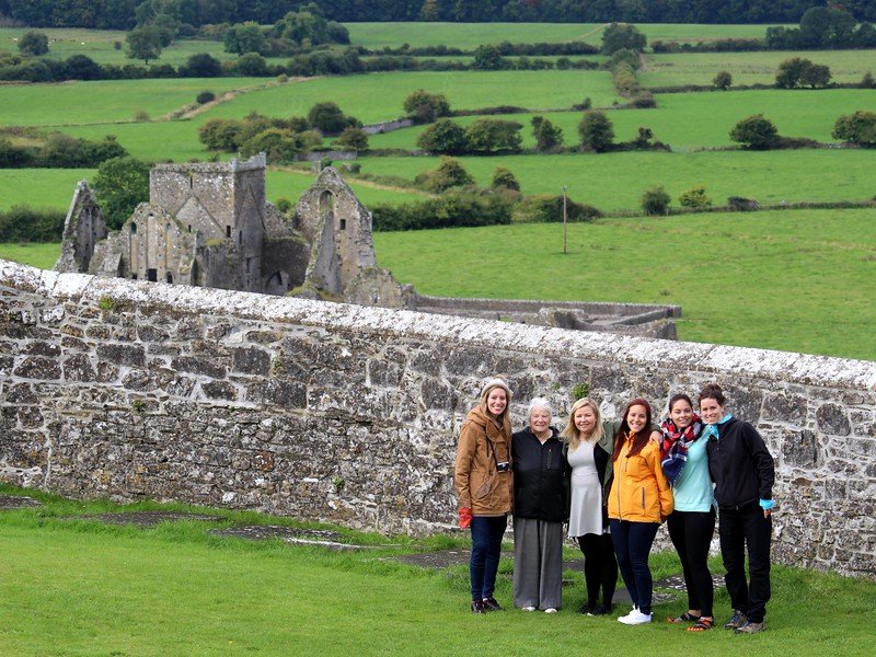 Visiting the Rock of Cashel with Hore Abbey in the background and That Backpacker Audrey Bergner posing with friends, family and locals!