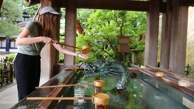 Visiting the temples and shrines in Takayama along the Higashiyama Walking Course with That Backpacker Audrey Bergner pouring water by a Dragonhead 