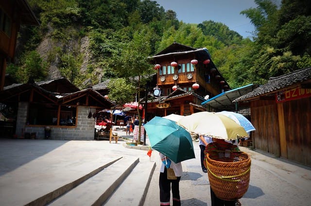 Visiting the village by the Longji rice terraces while traveling in China encountering those with umbrellas and baskets