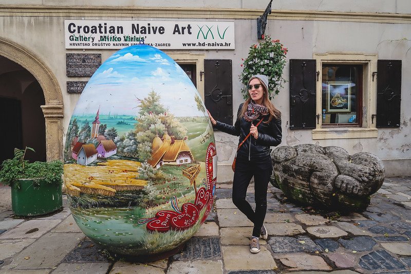 Visiting Zagreb on foot with That Backpacker Audrey Bergner posing by a giant easter egg in Croatia 