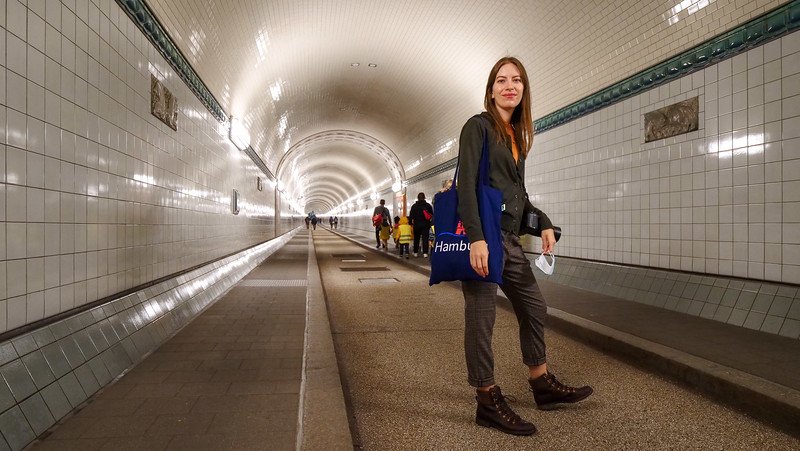 Walking across the Old Elbe Tunnel in Hamburg, Germany is That Backpacker Audrey Bergner with tote bag and camera on hands and shoulders Walking across the Old Elbe Tunnel in Hamburg, Germany is That Backpacker Audrey Bergner with tote bag and camera on hands and shoulders