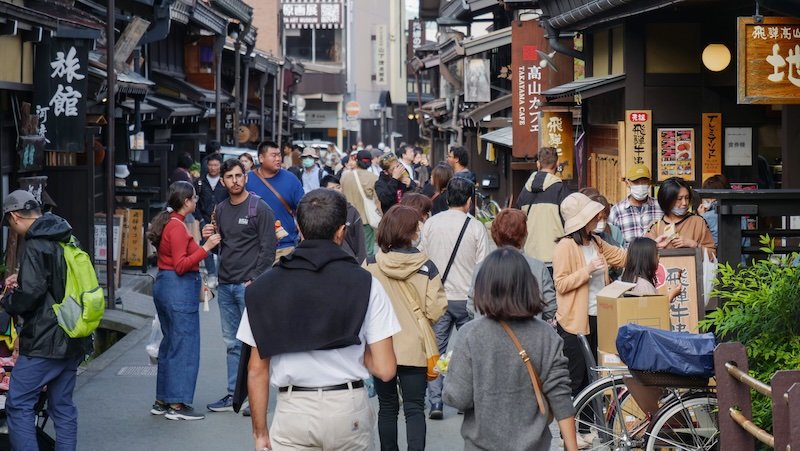 Walking is the most popular way to explore Takayama, Japan as indicated by this large group of tourists swarming in one area 