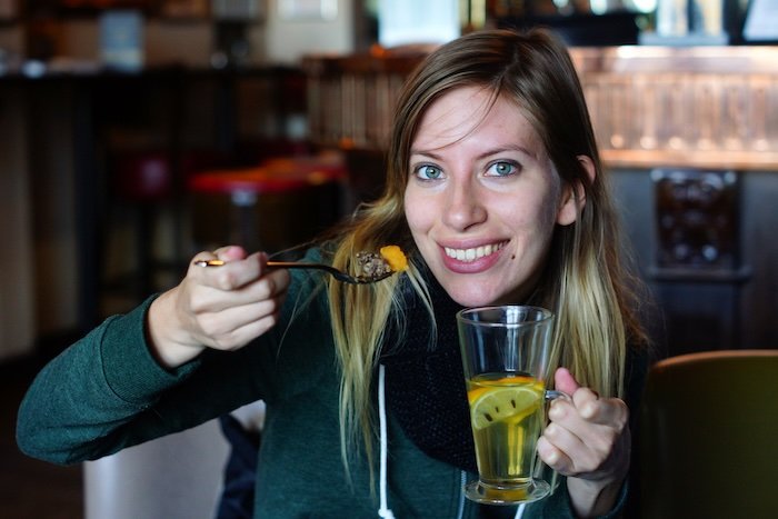 Warming up with Haggis, Neeps and Tatties and hot drink in hand is a smiling That Backpacker Audrey Bergner in Edinburgh, Scotland 