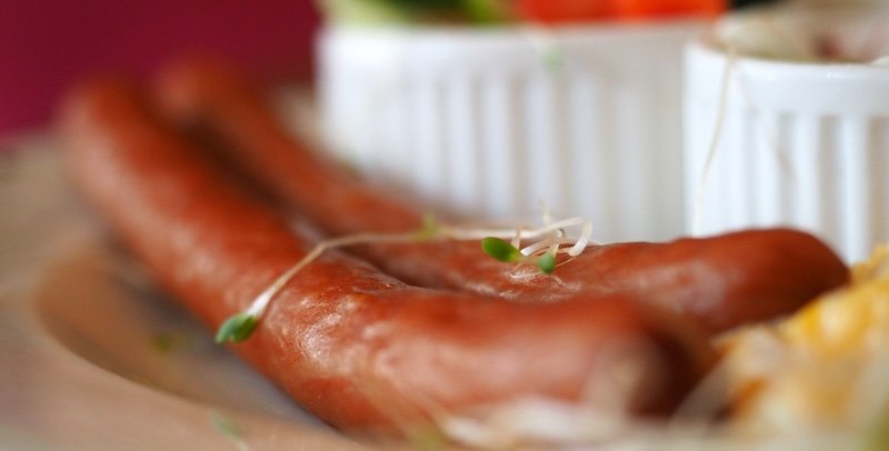 Close-up of traditional Polish kielbasa sausage served with sides in Warsaw, Poland. This macro food shot highlights the juicy texture and cultural importance of kielbasa, a staple of Polish cuisine and a must-try dish for foodies visiting Warsaw