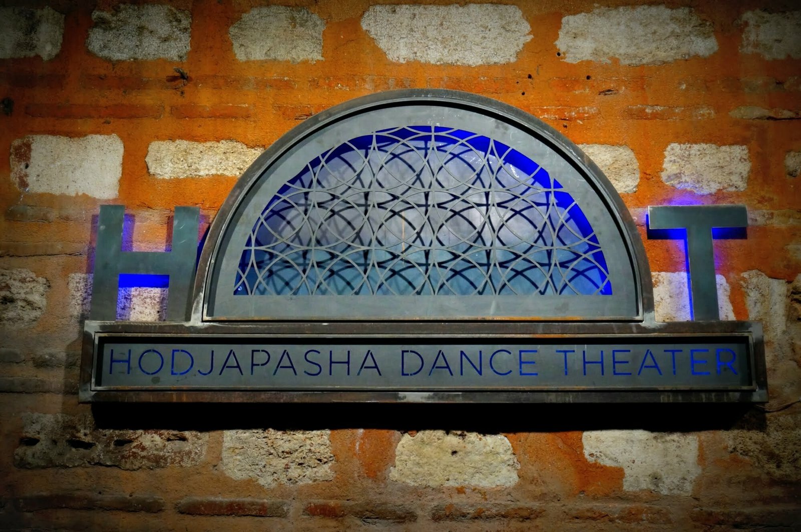 Whirling Dervishes at Hodjapasha Dance Theatre in Istanbul, Turkey with a special sign and logo outside on a brick wall 