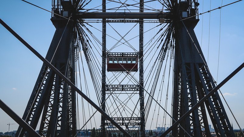 Close-up view of the towering steel structure and iconic red gondolas of the historic Wiener Riesenrad Ferris Wheel at Prater amusement park in Vienna, Austria Close-up view of the towering steel structure and iconic red gondolas of the historic Wiener Riesenrad Ferris Wheel at Prater amusement park in Vienna, Austria