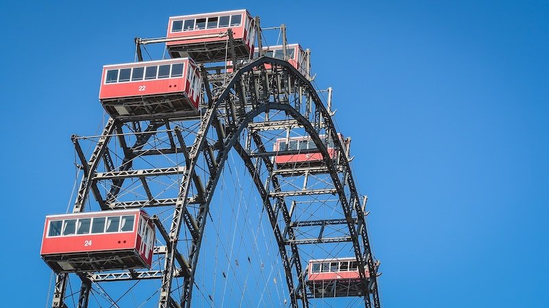 Close-up view of the iconic red gondolas on the Wiener Riesenrad Ferris wheel set against a clear blue sky in Vienna, Austria Close-up view of the iconic red gondolas on the Wiener Riesenrad Ferris wheel set against a clear blue sky in Vienna, Austria