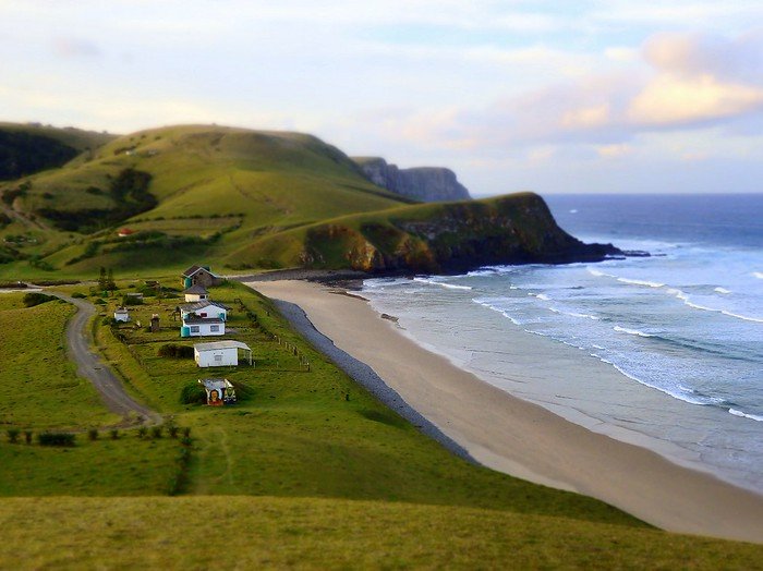 Wild Coast with Transkei views of the beach and small houses with rollings hills, dramatic cliffs and waves crashing in South Africa