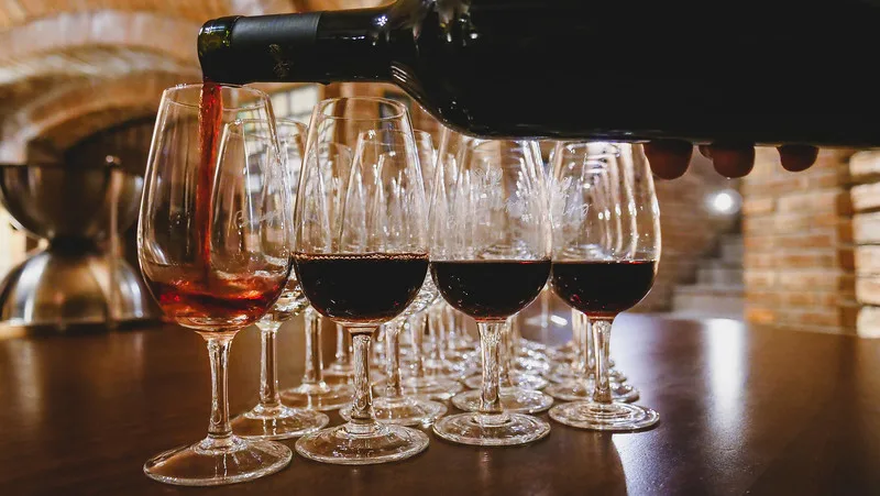 Wine tasting at Bodegas Lopez in Mendoza with wine being poured into the individual glasses