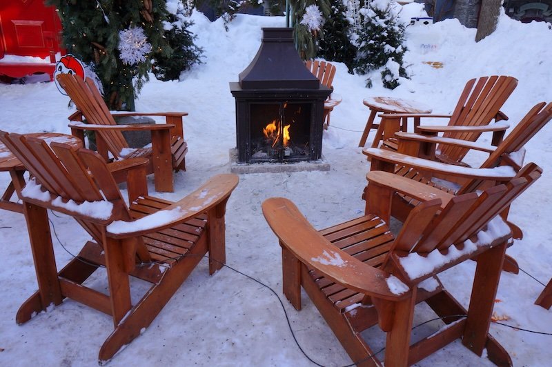 Winter fireplace with wooden chairs to stay warm in Quebec City Winter fireplace with wooden chairs to stay warm in Quebec City