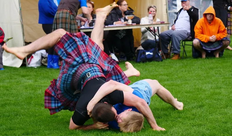 Wrestling competition at the Cowal Games with two men hitting the ground hard in Scotland 
