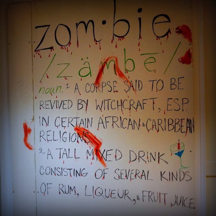 Zombie definition poster covered in fake blood escape room game in Chicago 