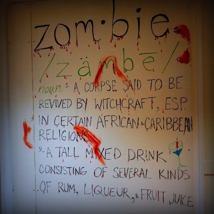 Zombie definition poster covered in fake blood escape room game in Chicago 